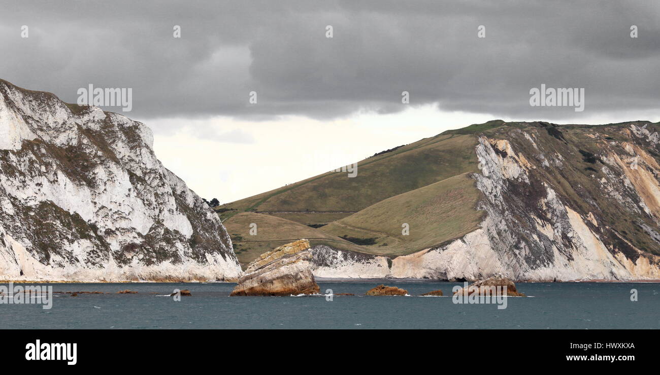 Falaises de craie et de premier plan des roches Mupe autour de droite par Arish Mell looking up Halcombe, Vale avec ciel dramatique, Dorset UK Banque D'Images