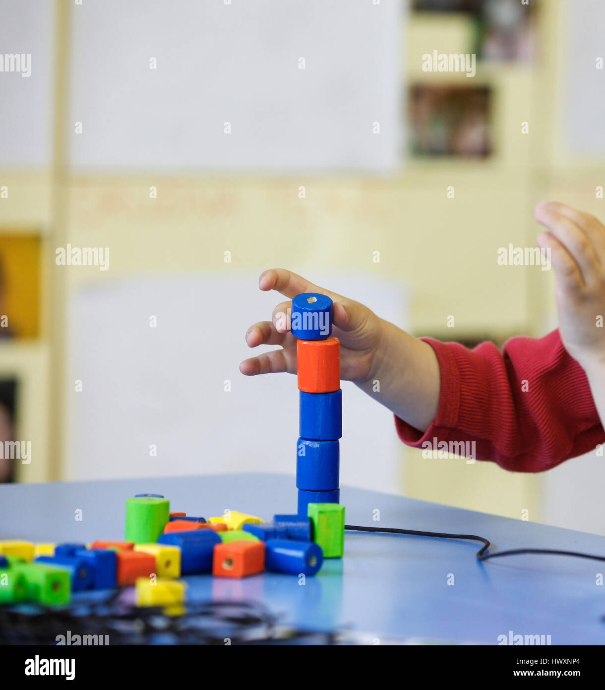 Enfant jouant avec des, do-it-yourself de jouets éducatifs, d'empilage et de l'organisation de pièces. Concept d'apprentissage par l'expérience, brut et f Banque D'Images