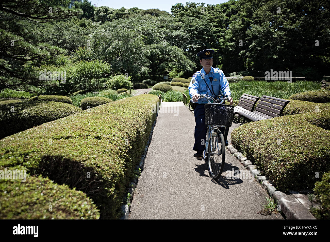 Un agent de police japonais faire du vélo dans un parc près du Palais Impérial de Tokyo à Tokyo, Japon. Banque D'Images