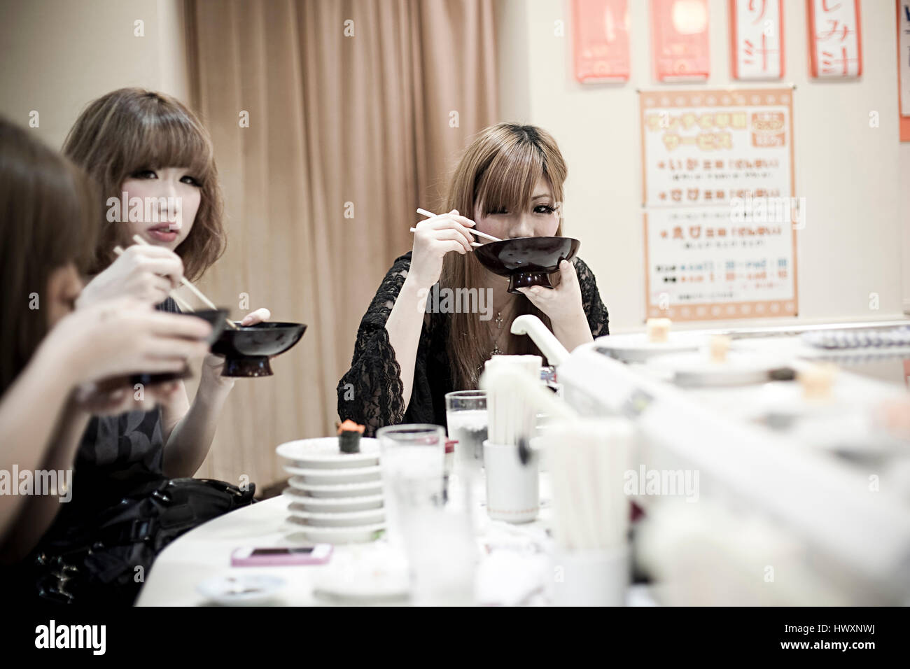 Trois filles japonaises à un restaurant de sushi à Tokyo, Japon. Banque D'Images