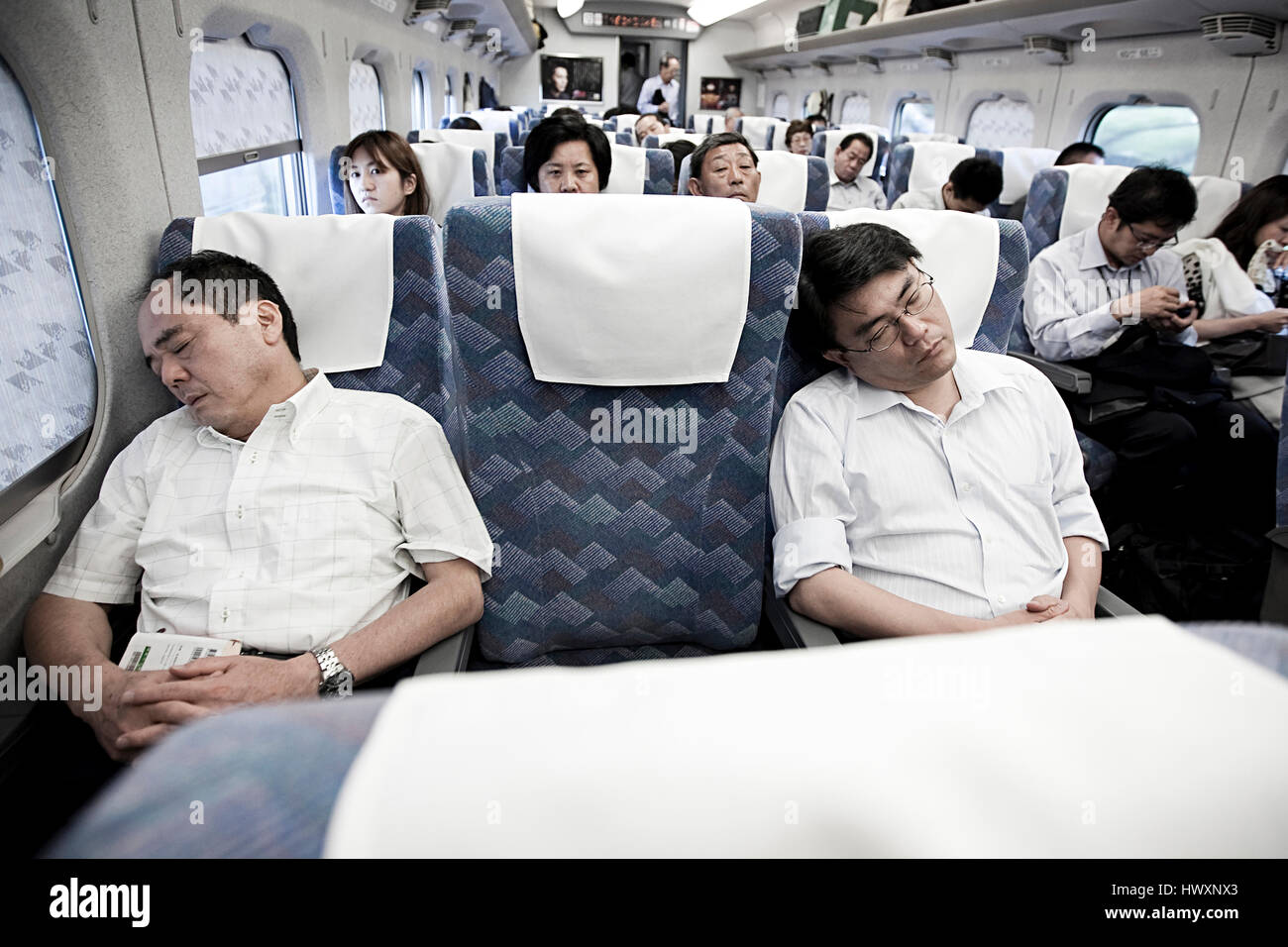 Deux hommes japonais à dormir dans un panier-train, au Japon. Voyage en train au Japon est une expérience à grande vitesse pour de nombreuses personnes étrangères. Banque D'Images