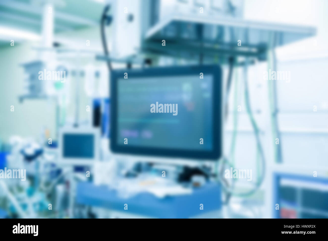 Résumé Contexte médical floue avec moniteur fonctionnel en salle d'opération avec des machines en arrière-plan, durant la chirurgie. Su la vie Banque D'Images