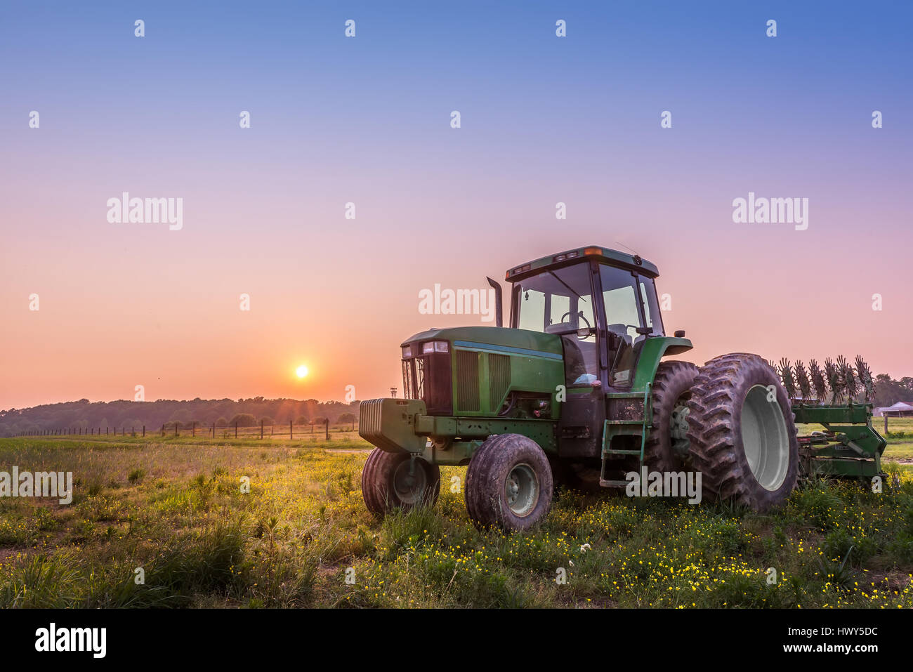Tracteur agricole dans un champ sur une ferme du Maryland avec coucher de soleil Banque D'Images