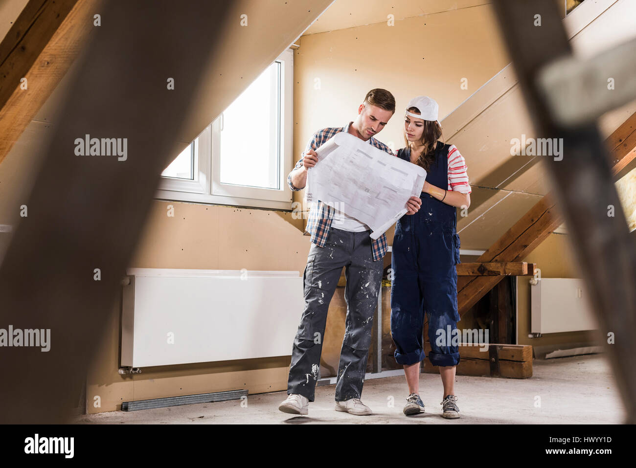 Jeune couple sur le site de construction de leur nouvelle maison, à la recherche de construction plan Banque D'Images
