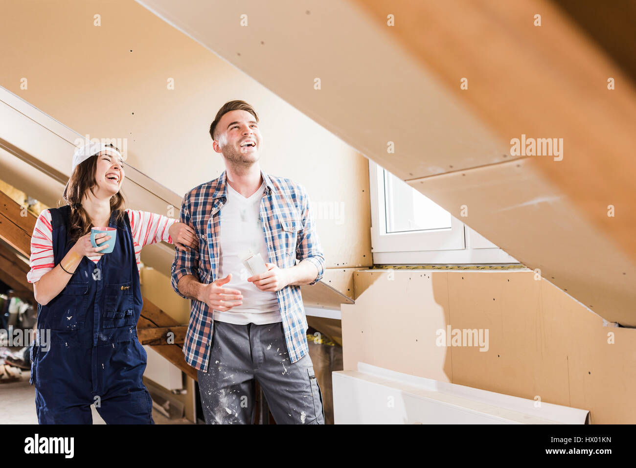 Jeune couple sur le site de construction de leur nouvelle maison, à la recherche de construction plan Banque D'Images