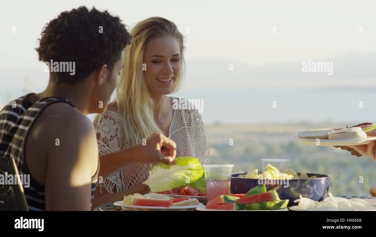 Selective focus view of couple eating outdoors près de vue panoramique de paysage à distance Banque D'Images