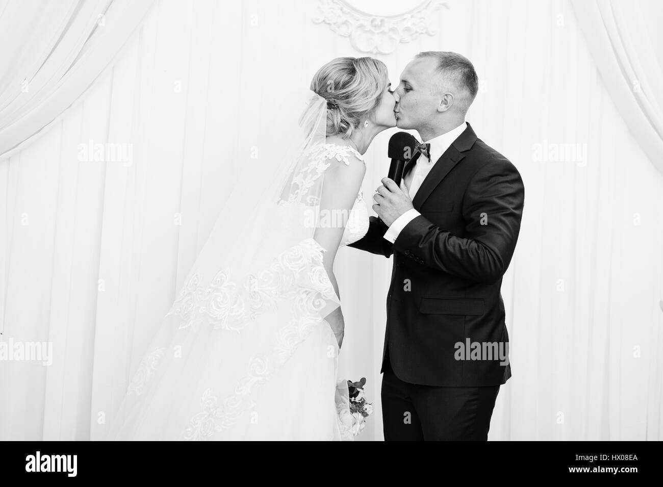 Bride and Groom kissing après discours lors de la cérémonie du mariage. Banque D'Images