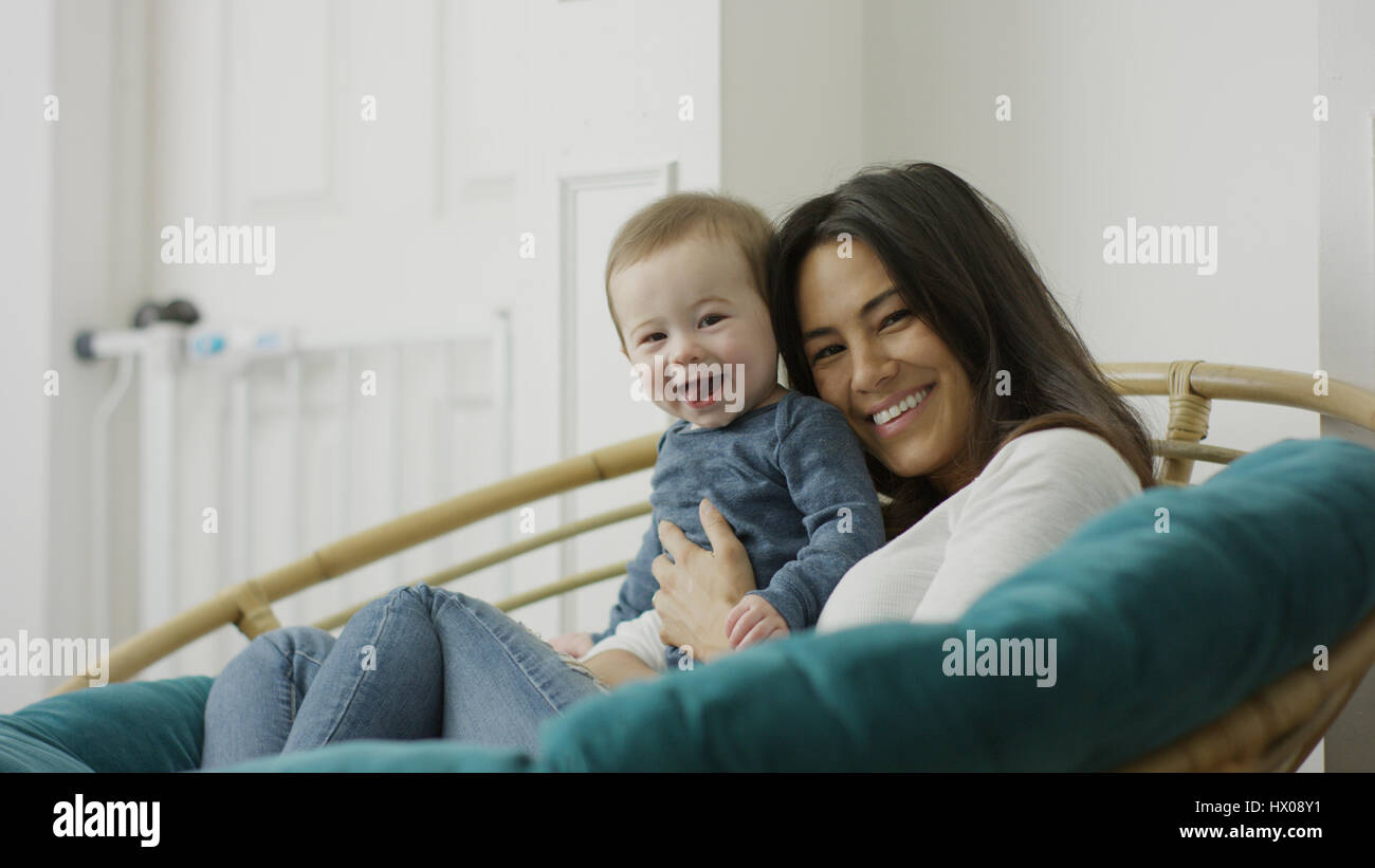 Low angle portrait portrait de mère et bébé fils posant et sitting in chair Banque D'Images