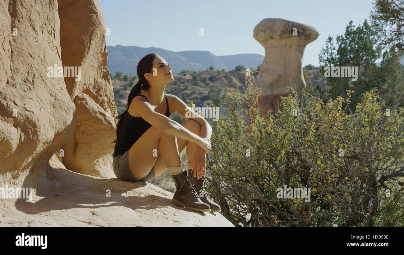 Smiling kayak de falaise rocheuse admirant vue panoramique des formations rocheuses et arbres dans paysage de désert à distance Banque D'Images
