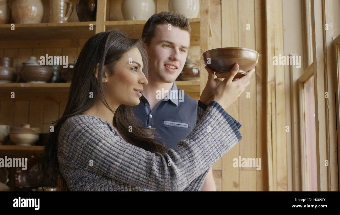 Low angle view of petit ami et petite amie admirant Bol en céramique fait main en magasin Banque D'Images