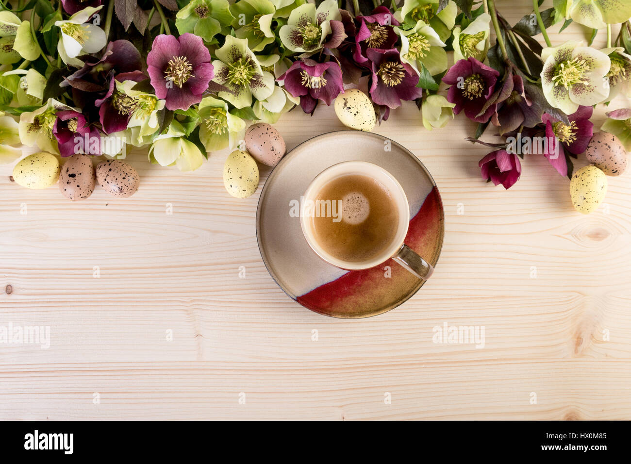 Tasse de café haut Vue sur fond en bois avec fleurs de printemps et les oeufs de Pâques. Style rétro, des couleurs pastel. Banque D'Images