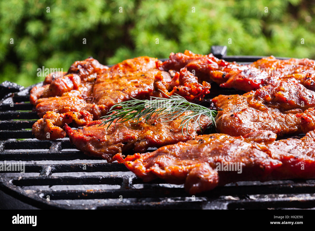 Griller des steaks de porc sur la grille du barbecue. Selective focus Banque D'Images