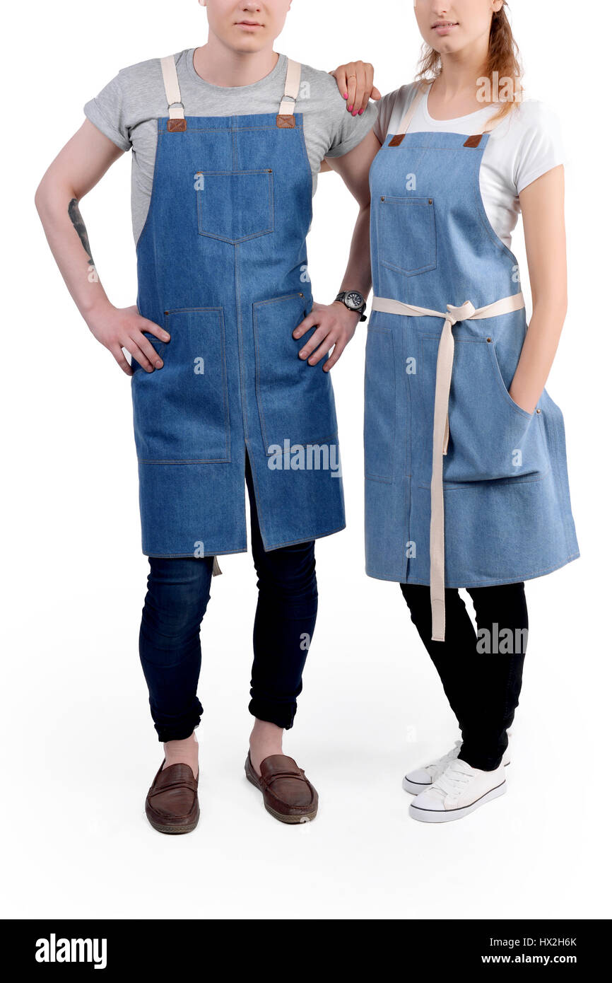 Jeunes chefs ou maîtres d'homme et de la femme pose, portant des tabliers isolé sur fond blanc. Banque D'Images