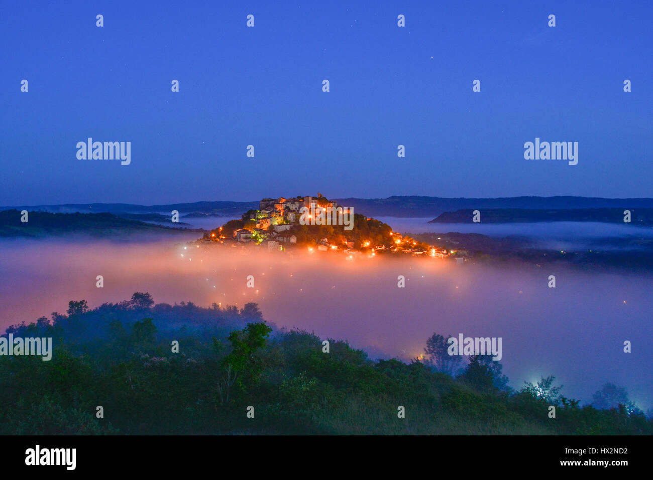 La superbe, au sommet d'une colline, village médiéval de Cordes-sur-Ciel, en Occitanie, en France avant l'aube, la lumière. Banque D'Images