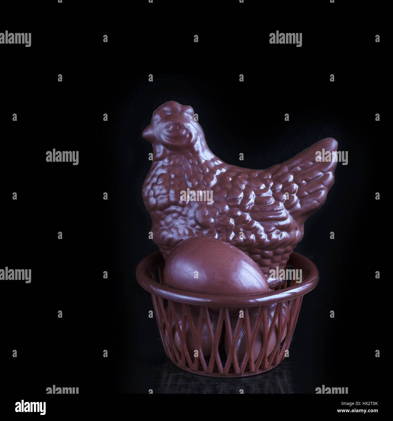 Poulet au chocolat et des œufs de Pâques en panier. Banque D'Images