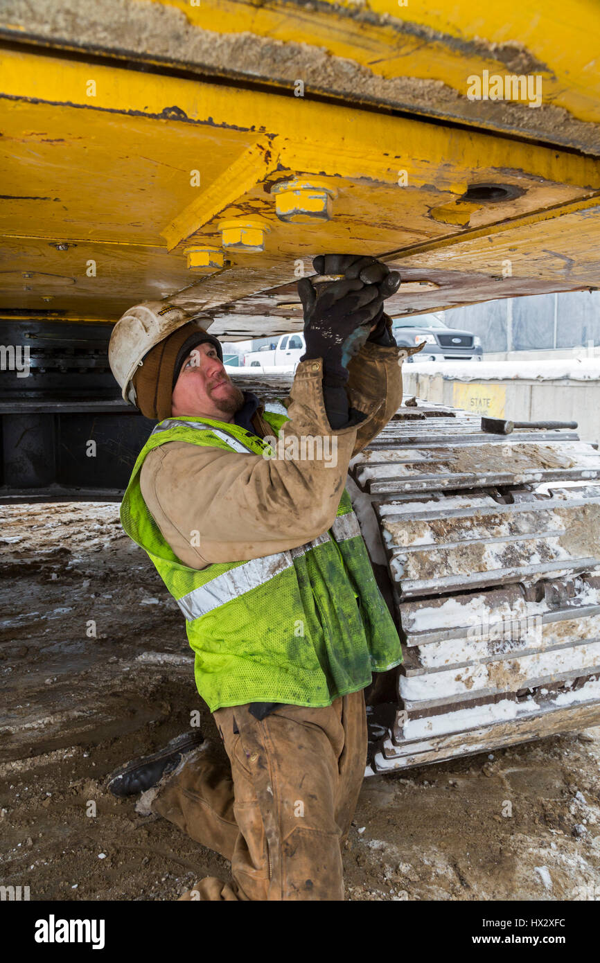 Mt. Clemens, Michigan - un travailleur pour Homrich, un entrepreneur de démolition, prépare l'équipement lourd pour le transport à l'emplacement d'un garage de stationnement demoliti Banque D'Images