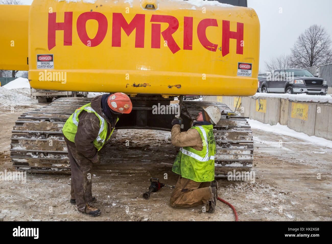 Mt. Clemens, Michigan - Travailleurs pour Homrich, un entrepreneur de démolition, préparer l'équipement lourd pour le transport à l'emplacement d'une démolition d'un garage de stationnement Banque D'Images