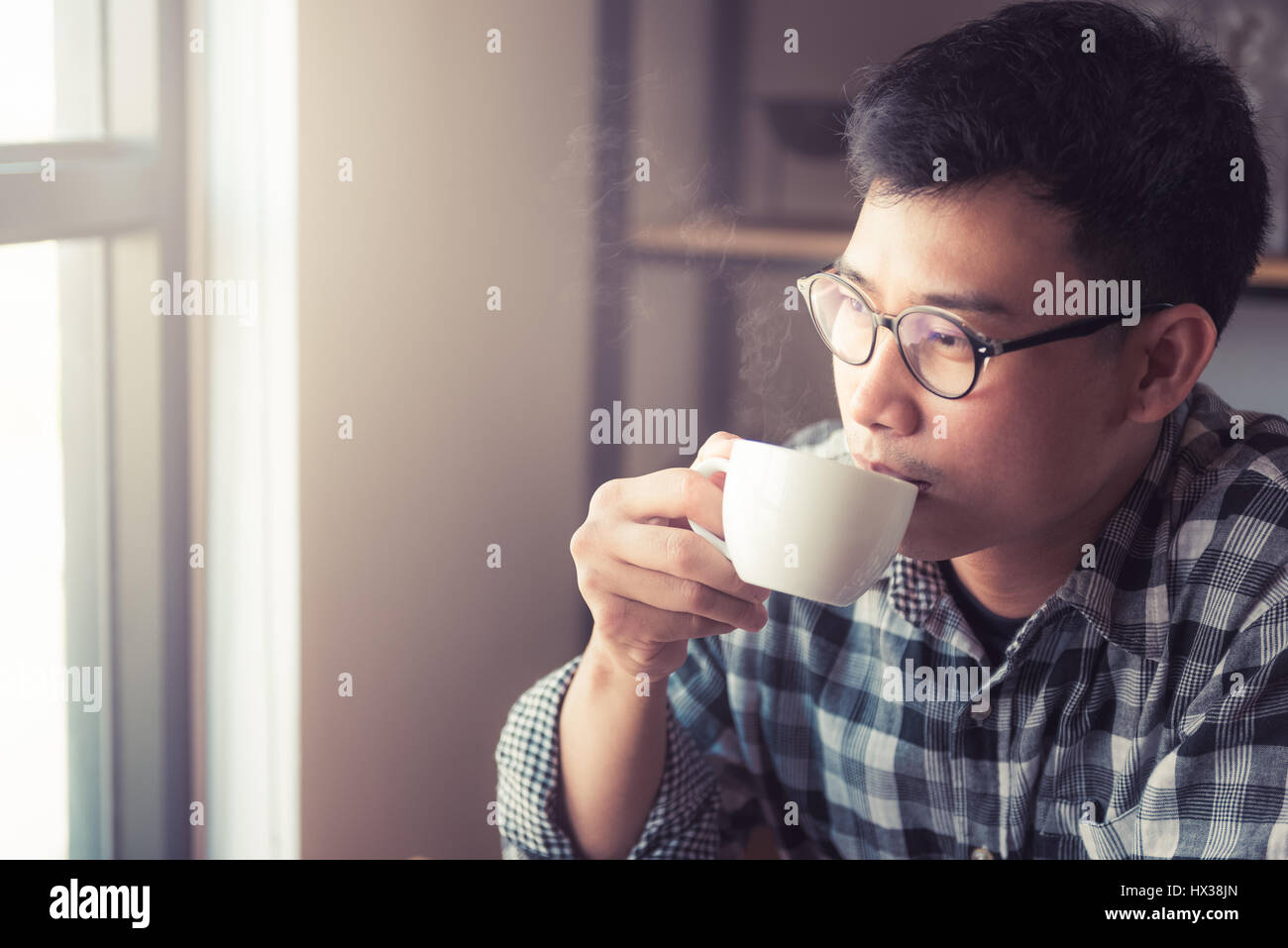 Un jeune homme asiatique boit du café., Comment faire pour le style de vie des jeunes hommes d'affaires asiatiques dans l'activité de week-end détente avec le café. Boire Banque D'Images