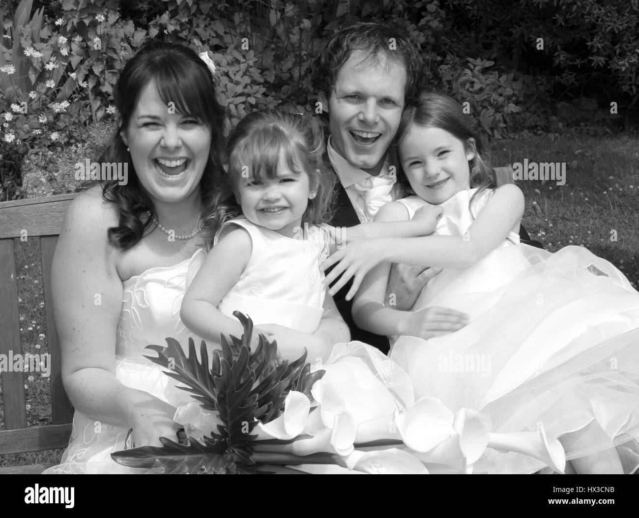 Bridesmaids mariée marié et ayant l'amusement sittng sur un banc Banque D'Images