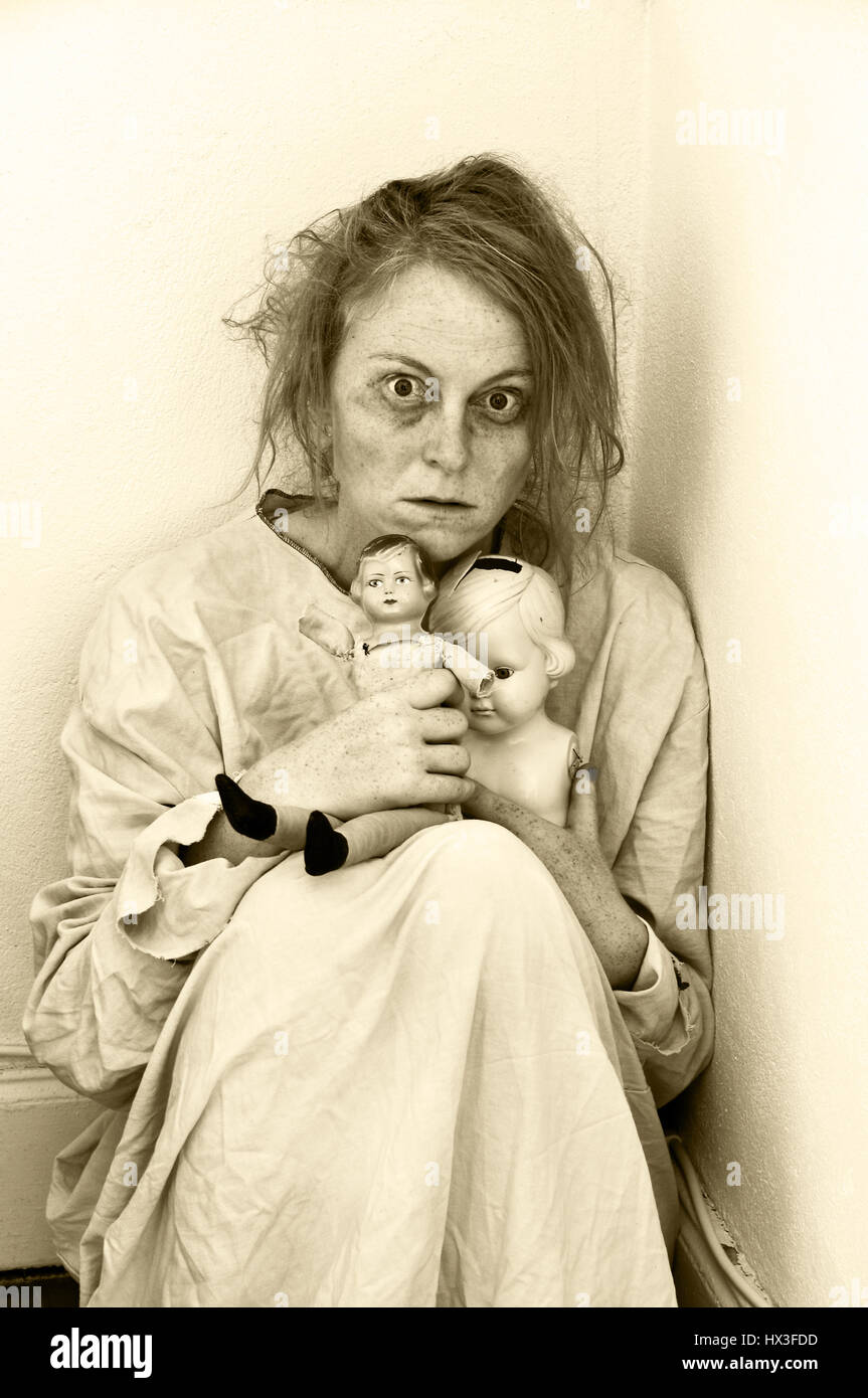 Femme dans un service de psychiatrie avec deux poupées. Banque D'Images