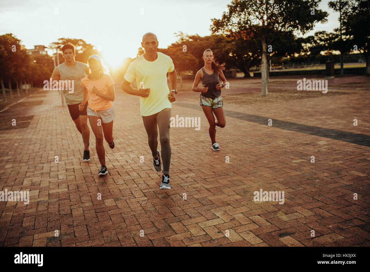 Un groupe d'athlètes tournant au parc de la ville. Les coureurs de sportswear formation ensemble à l'extérieur. Banque D'Images