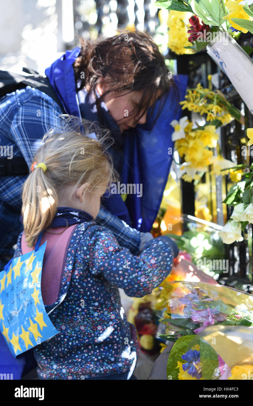 Fille de placer des fleurs. Fleurs attaché à la clôture au Palais de Westminster par marcheurs manifestant contre 'Brexit'. Ils ont été mis à l'honneur les vies perdues lors de l'attaque terroriste Banque D'Images