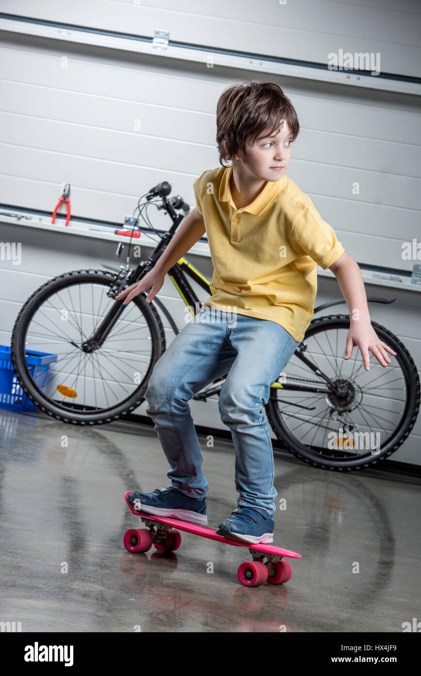 Adorable garçon avec penny rose, location derrière Banque D'Images