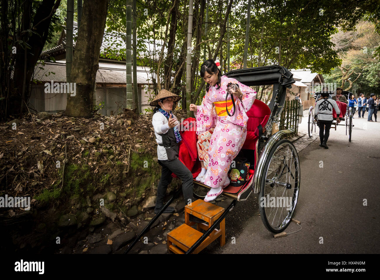 Un pousse-pousse tiré par un homme dans l'uniforme de travail traditionnelles et d'une passagère en kimono, le costume traditionnel japonais, Kyoto, Japon Banque D'Images