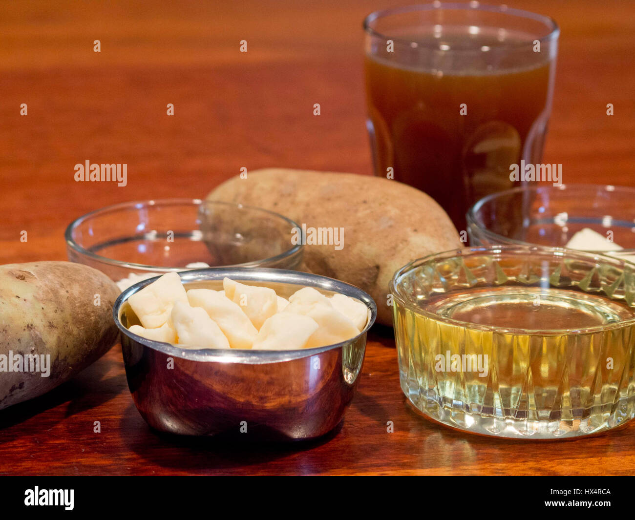 Ingrédients pour faire de la poutine y compris les différentes pâtes, l'huile, la pomme de terre, le bouillon de bœuf, de la farine, et le beurre. Banque D'Images