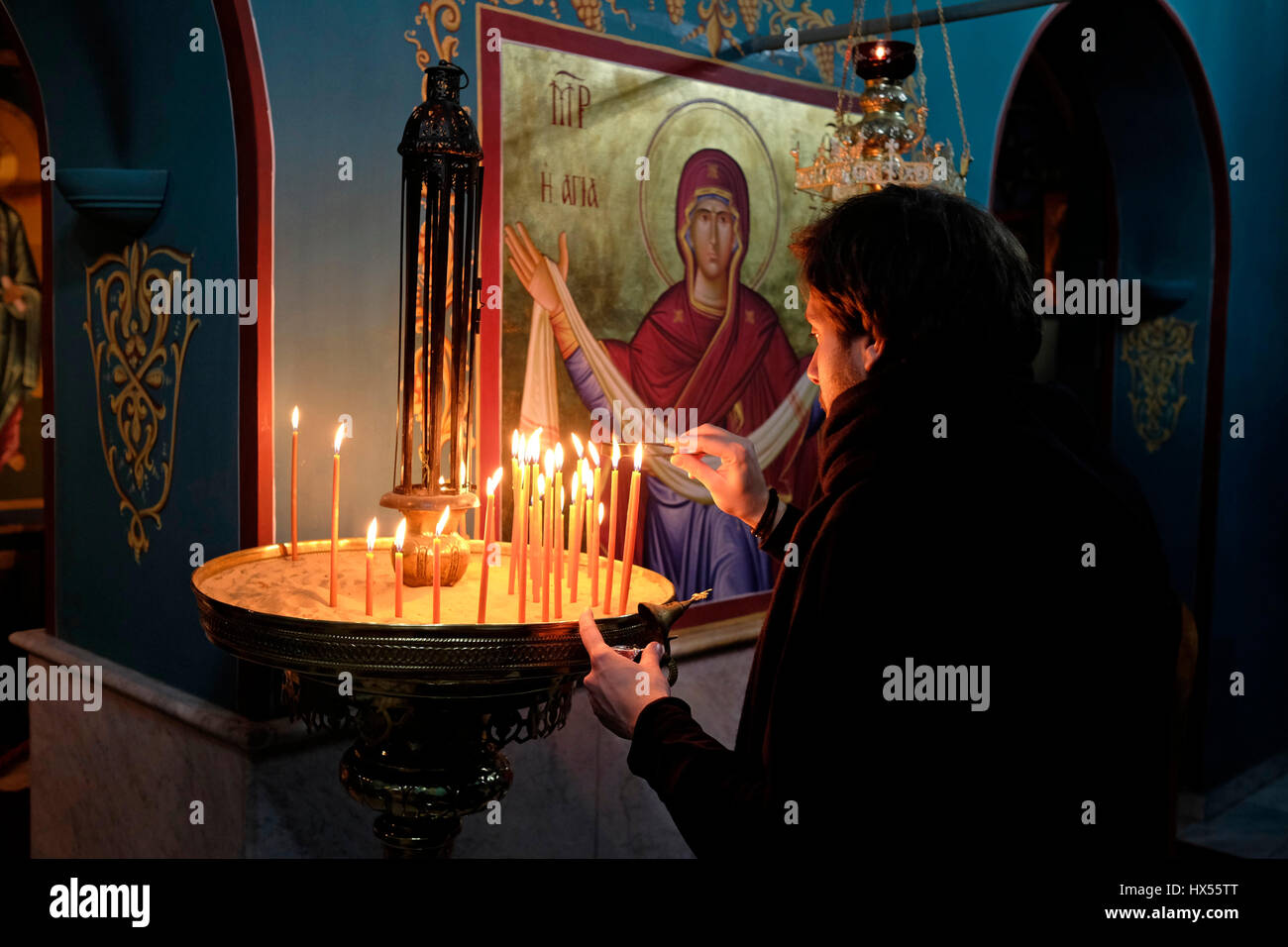 Un adorateur chrétien orthodoxe allume des bougies à l'intérieur de  l'église du monastère grec orthodoxe, connu sous le nom de Gethsemane  Metoxion où une célèbre icône de Sainte Marie se tient toute
