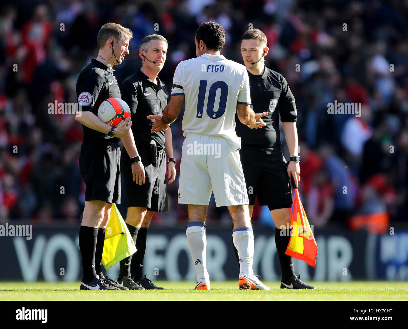 Luis Figo du Real Madrid (centre) s'entretient avec match arbitre Darren Bond (deuxième à gauche) au cours de l'organisme de bienfaisance match à Anfield, Liverpool. Banque D'Images