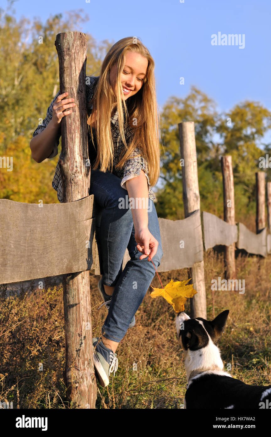 Cheerful businesswoman standing avec chien non consanguins dans la journée d'automne Banque D'Images