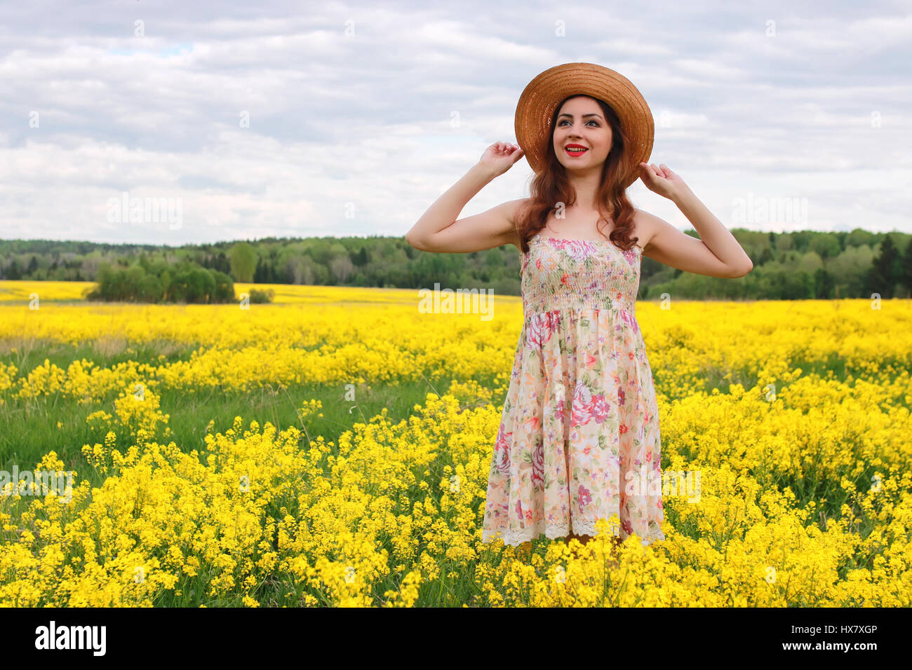 Jeune fille dans un champ de fleurs avec panier et un chapeau Photo Stock -  Alamy