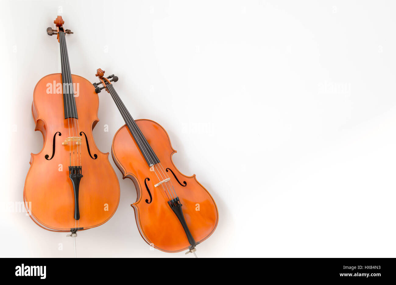 Photographie en couleur de deux violoncelles, un pleine hauteur et un quart de la taille sur un fond blanc. Banque D'Images