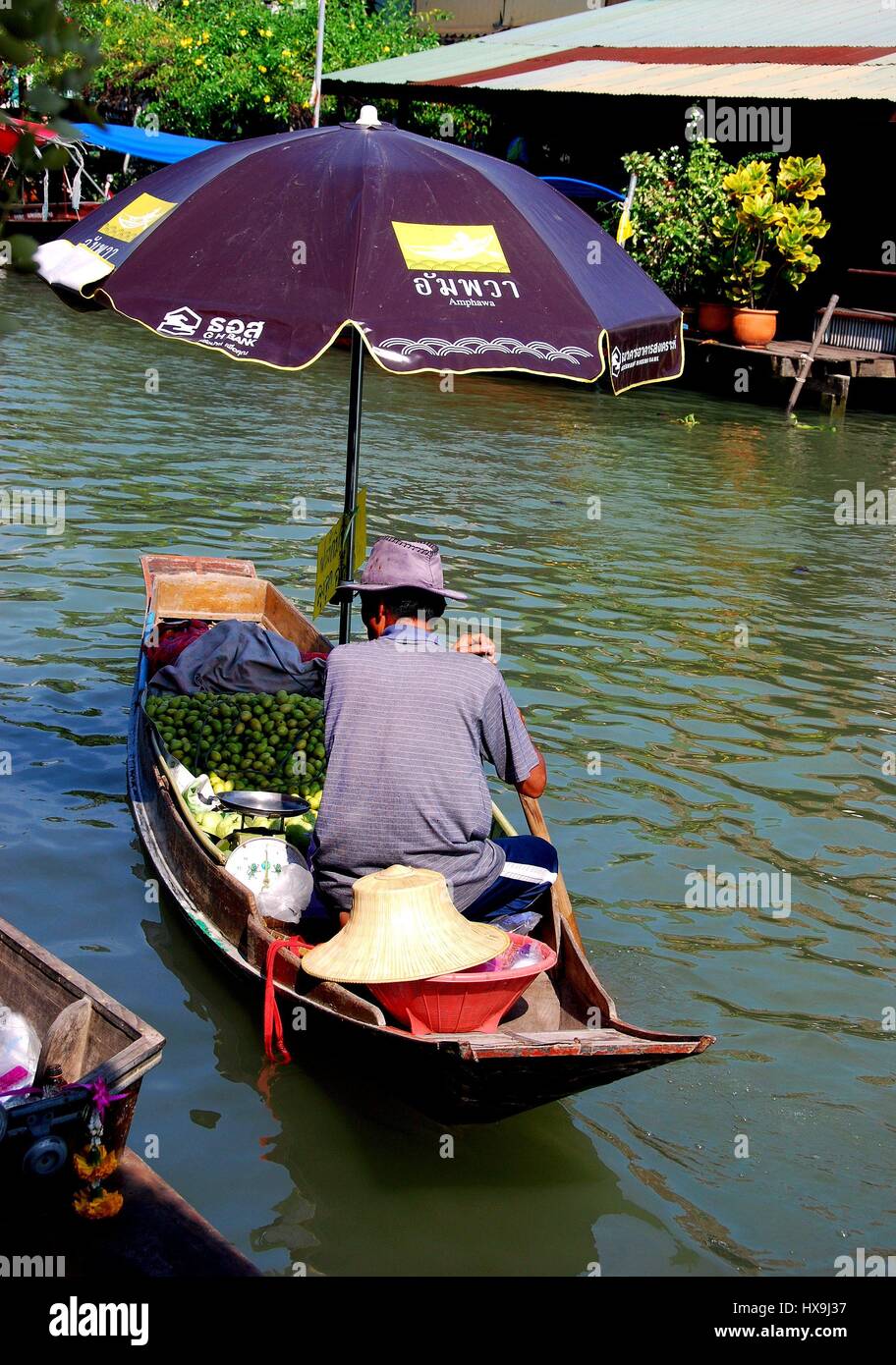 Amphawa, Thaïlande - 17 décembre 2010 : vendeur oriente son petit bateau en bois remplis de fruits le long de la rivière Mae Klong au flottant Amphawa Marke Banque D'Images
