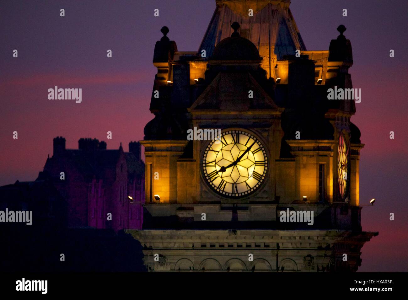 Edinburgh, Royaume-Uni. Mar 26, 2017. Coucher de soleil depuis l'Edimbourg Calton Hill. L'horloge de l'hôtel Balmoral est au premier plan avec le château illuminé en complimentant violet les couleurs chaudes du coucher de soleil. Credit : Riche de Dyson/Alamy Live News Banque D'Images