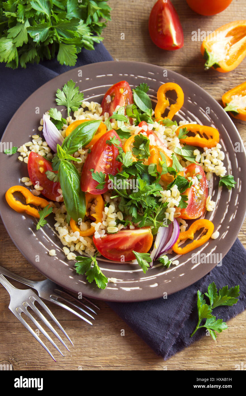 Salade de couscous et de tomates avec des légumes et des verts - vegan végétarienne saine alimentation bio végétale alimentaire salade sur table en bois rustique avec copie s Banque D'Images