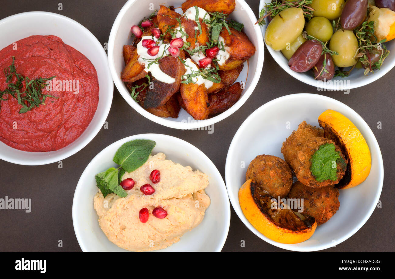 Moyen-orientaux sélection de plats végétariens ; - muhamarra, olives, betteraves, pommes de terre à l'hummus et beignets de courge musquée - Banque D'Images