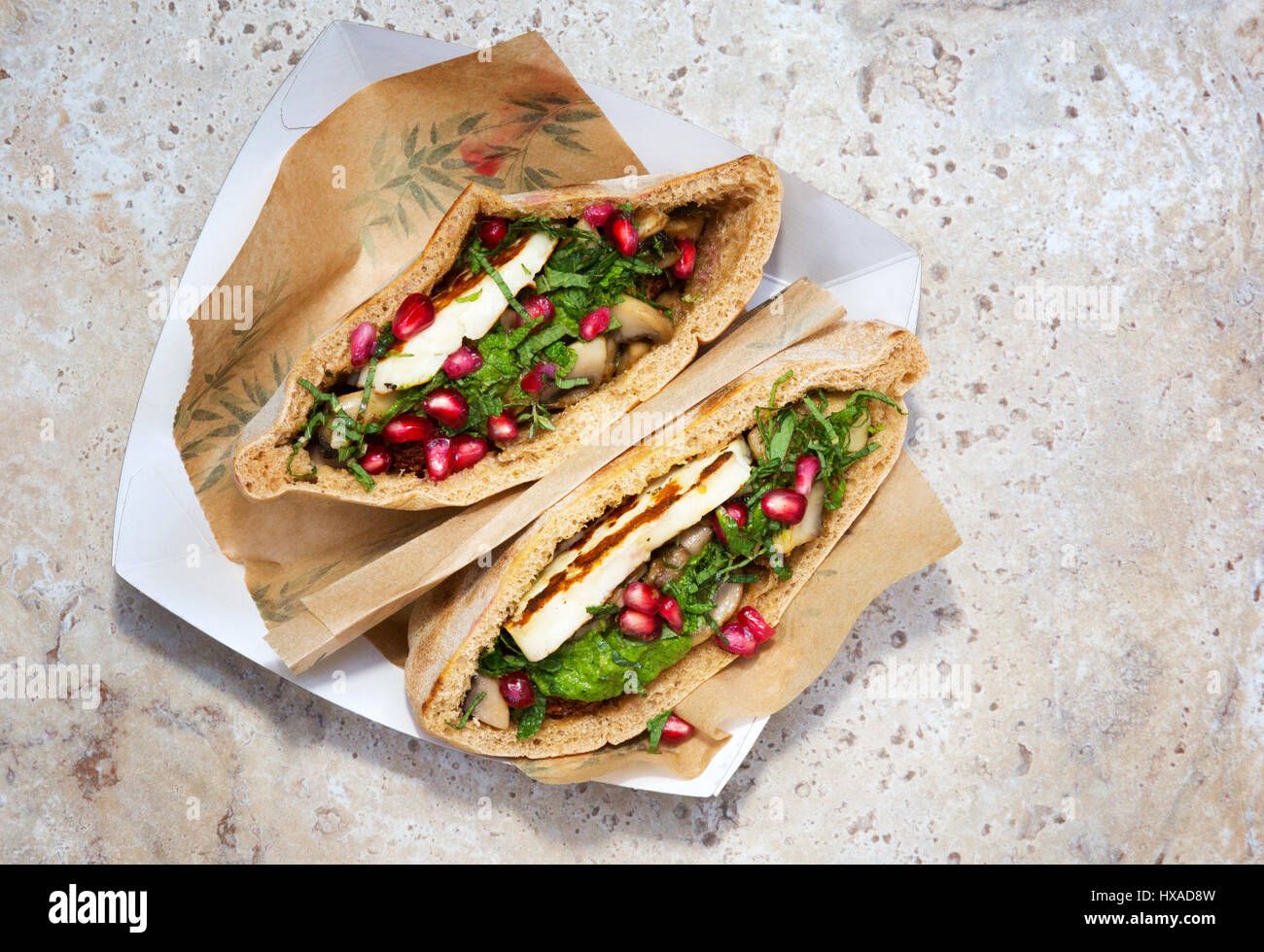 La nourriture végétarienne - pitta farcie avec haloumi, champignons, zough, de menthe et de graines de grenade, l'exemple de l'alimentation de rue, UK Banque D'Images