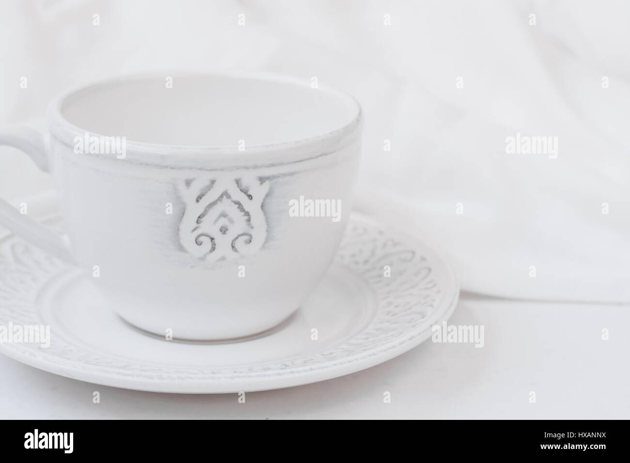 Thé coupe céramique relief blanc avec une soucoupe sur la table de bois, tissu de coton, concept de pureté de style minimaliste, de droit sur les médias sociaux, la bannière, l'en-tête Banque D'Images