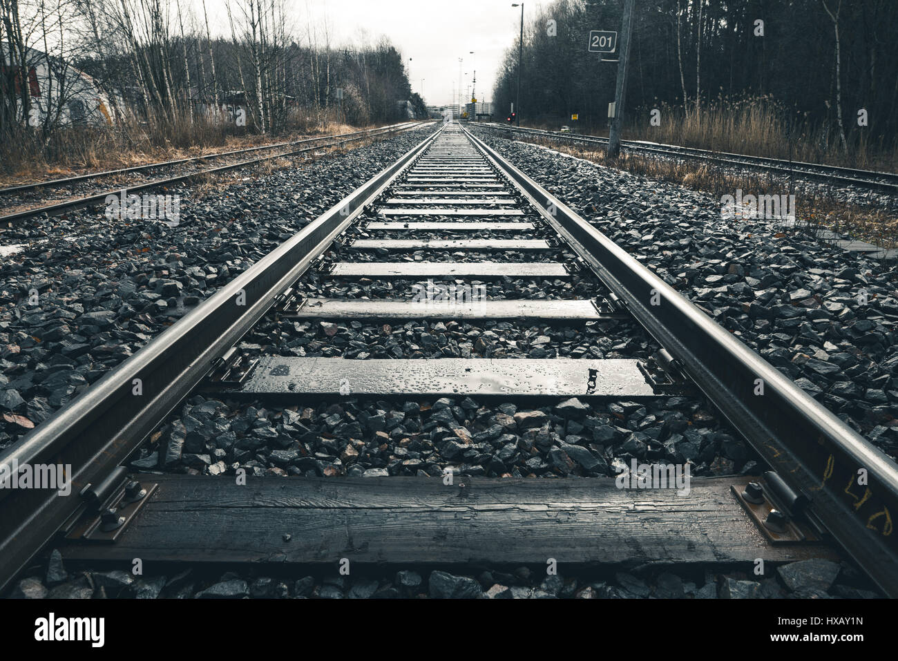 Large et low angle view of railroad tracks avec un contraste élevé par temps nuageux et pluvieux Banque D'Images