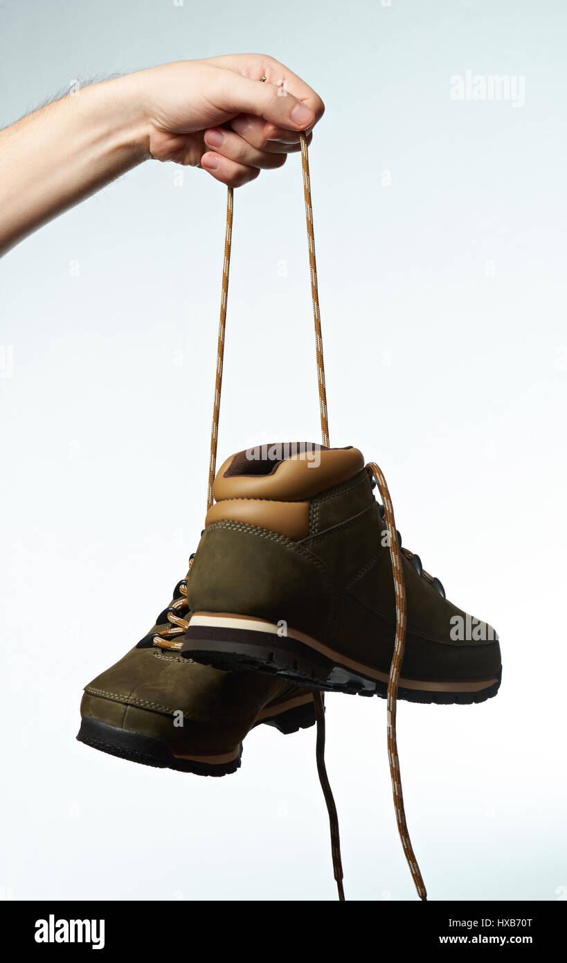 Chaussures de randonnée accrocher sur lacets isolé sur fond blanc. Main  courante sur lacets chaussures de plein air Photo Stock - Alamy