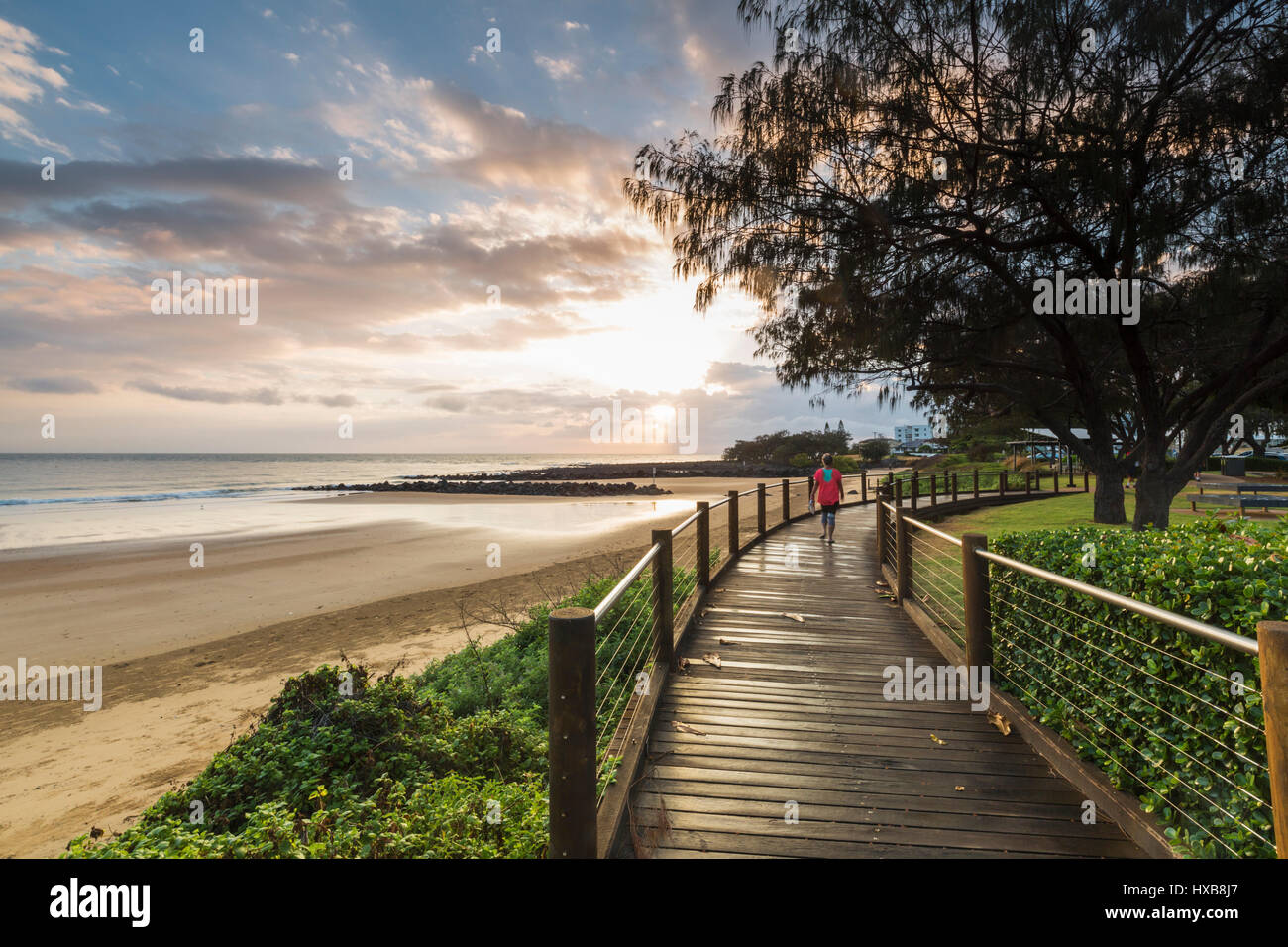 Walker tôt le matin sur l'Esplanade promenade de plage de Bargara, Bundaberg, Queensland, Australie Banque D'Images