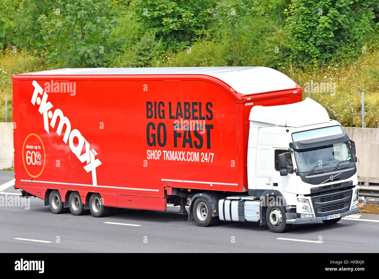 TK Maxx rouge du côté de la publicité mobile shop livraison simplifiée long et blanc remorque camion Volvo poids lourds grand chariot roulant sur autoroute English UK Essex Banque D'Images