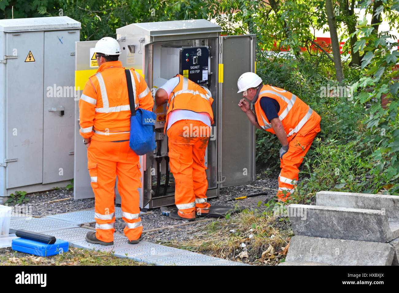 Les travailleurs des chemins de fer britanniques en matière de santé et de sécurité et du casque de travailler ensemble Veste haute visibilité sur l'équipement à côté des rails de chemin de fer de l'emploi en milieu de plein air Banque D'Images