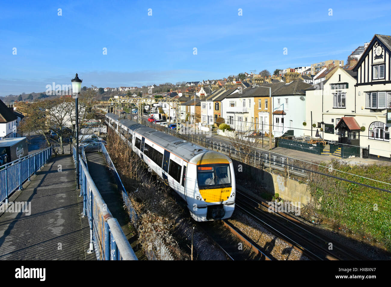 Train Trenitalia c2c avec marquage National Express bruit passant à proximité des maisons rue résidentielle dans la ville balnéaire de Leigh on Sea Essex Angleterre Banque D'Images