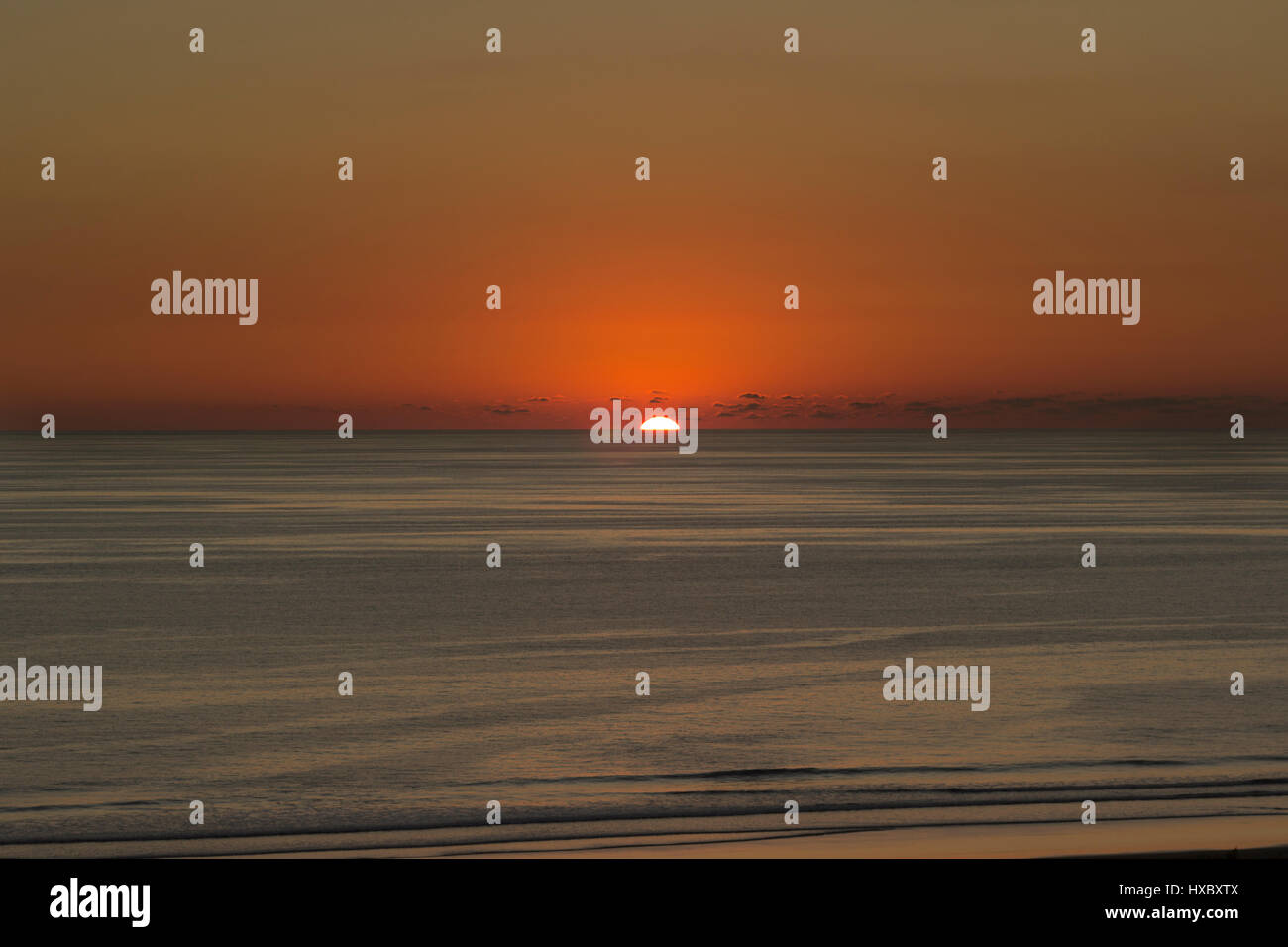 Coucher de soleil sur l'océan Pacifique. Le soleil est une boule de feu rouge coulant au-dessous de l'horizon au-dessus de l'océan Pacifique du Costa Rica. Banque D'Images