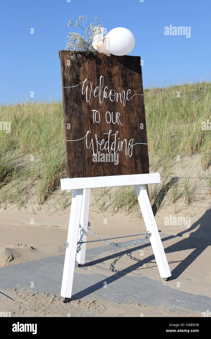 Chevalet en bois avec Bienvenue à notre mariage devant des dunes Banque D'Images