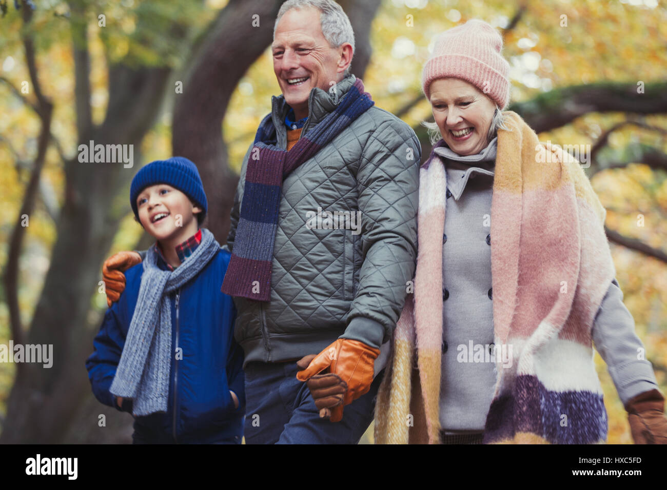 Les grands-parents à marcher avec petit-fils in autumn park Banque D'Images