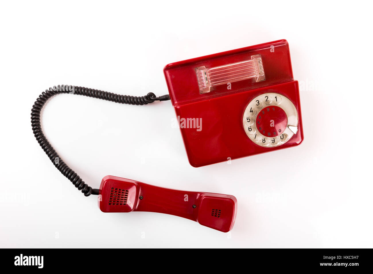 Vieux téléphone rouge avec cadran rotatif sur fond blanc Banque D'Images